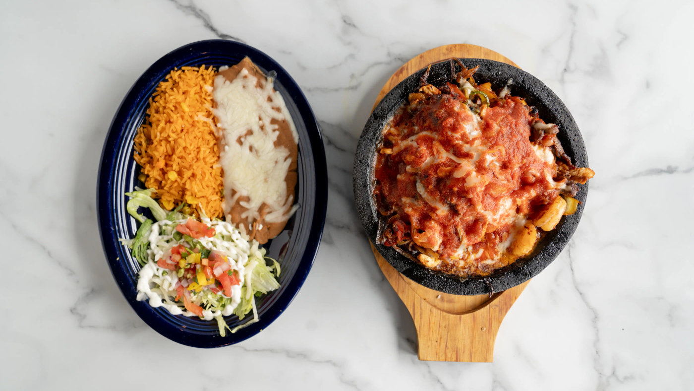 Steak, chicken, and shrimp grilled with bell peppers, onions, tomatoes, and pineapple. Topped with Monterrey Jack cheese and special read sauce, on a sizzling hot authentic Mexican molcajete. Served with rice, beans, sour cream, lettuce, pico de gallo, and three corn or flour tortillas